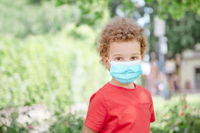 Boy plays outdoors in spring with mask