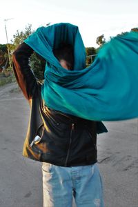 Midsection of woman with umbrella walking on road