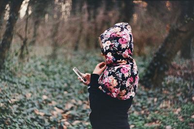 Woman using mobile phone at forest