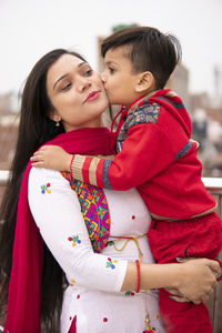 Mother and son embracing while standing outdoors