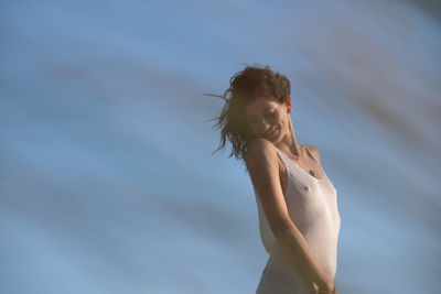 Side view of woman standing against sky during sunset