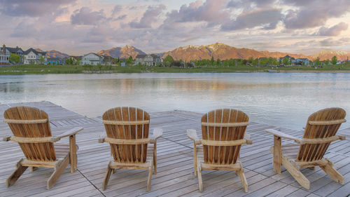 Empty chairs and table by lake