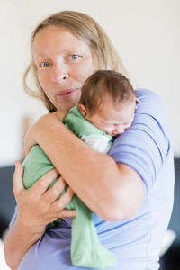 Portrait of grandmother holding baby at home