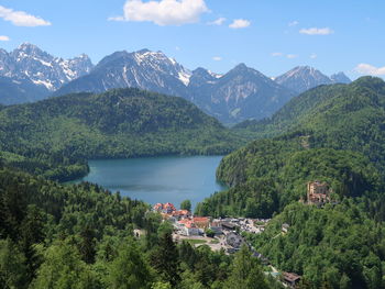 Scenic view of townscape by mountains against sky