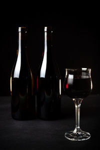 Close-up of wine bottles on table against black background