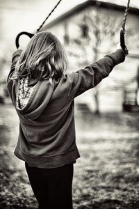 Teenage girl holding gymnastic rings while standing outdoors