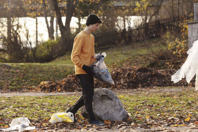 Side view of man standing against trees