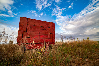 Abandoned barn on field against sky