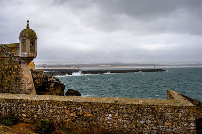 Sea by buildings against sky