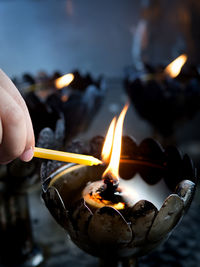 Close-up of hand holding burning candle