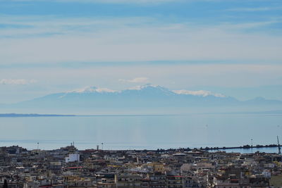 High angle view of townscape by sea against sky