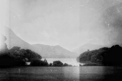 Scenic view of lake by mountains against sky