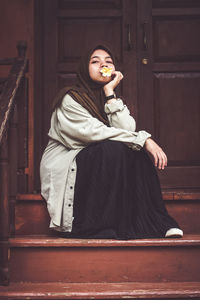 Portrait of a young woman sitting outdoors