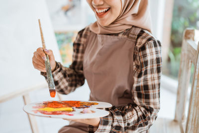 Midsection of woman having food at home