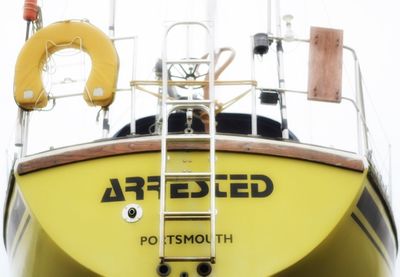 Close-up of yellow information sign in water