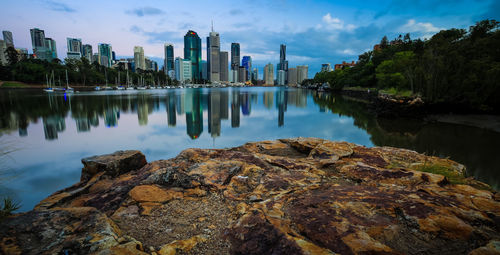 Brisbane river by city against sky