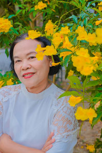 Portrait of a smiling girl with yellow flower