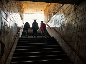 Rear view of people walking on stairs