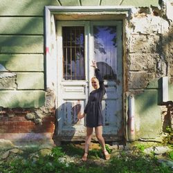 Full length of woman standing against building