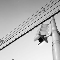 Low angle view of power lines against clear blue sky