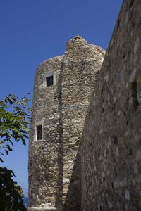 Low angle view of historic building against clear blue sky