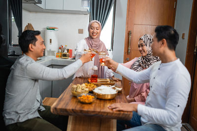 Rear view of woman having food at home