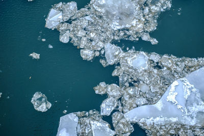 High angle view of frozen sea by rock