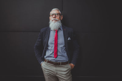 Businessman standing against black wall
