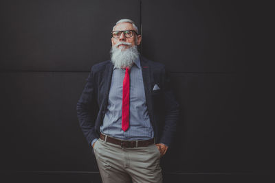 Businessman standing against black wall