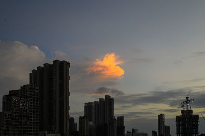 Modern buildings in city against sky during sunset