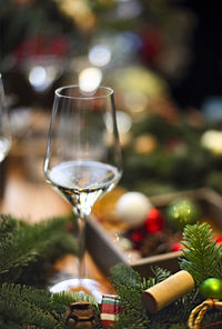 Close-up of wine glass on table against christmas tree