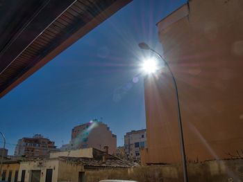 Low angle view of buildings against sky on sunny day