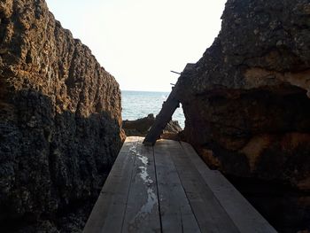 Rock formations by sea against clear sky