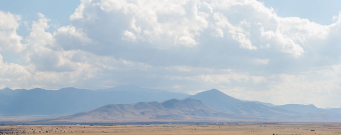 Scenic view of mountains against cloudy sky