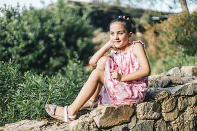 Cute girl sitting on rock