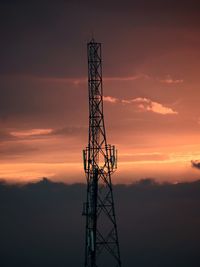 Low angle view of silhouette communications tower against sky during sunset