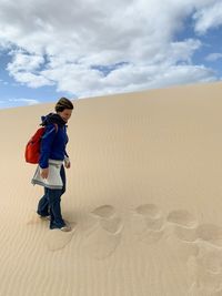 Rear view of boy on sand dune