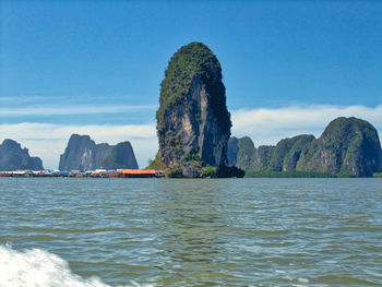 Rock formations in sea against sky
