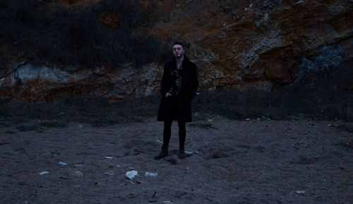 Full length portrait of woman standing on land