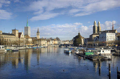 Scenic view of lake zurich amidst buildings in city against sky