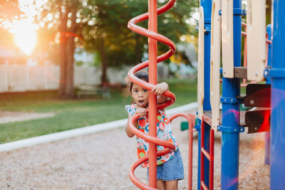 Diverse mixed race pre school girl outdoors during summer having fun at playground park 