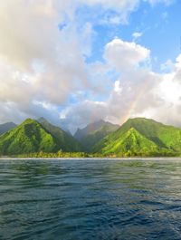 Scenic view of sea and mountains against sky