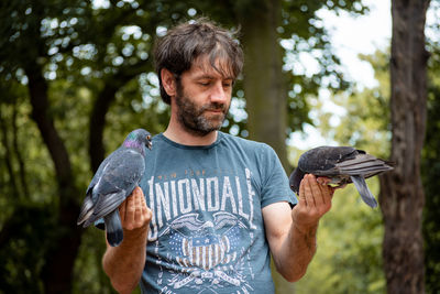 Portrait of young man feeding bird