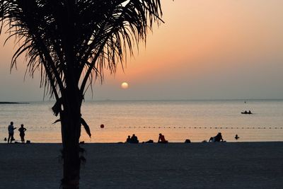 Silhouette people on beach during sunset
