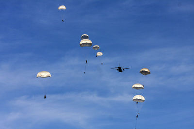 Low angle view of person paragliding against clear blue sky