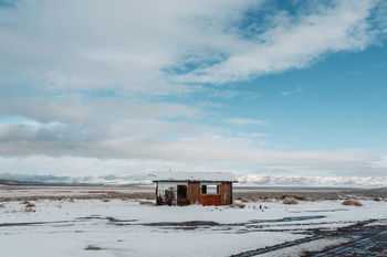 BUILDING ON SNOW COVERED LAND AGAINST SKY