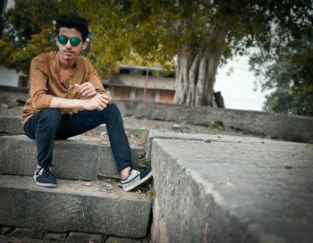 Full length of teenage boy sitting on steps