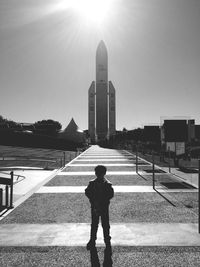 Full length of man standing on road against sky during sunny day