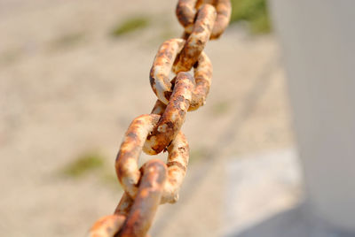Close-up of rusty chain tied to metal