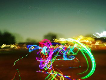 Multi colored light trails in sky at night